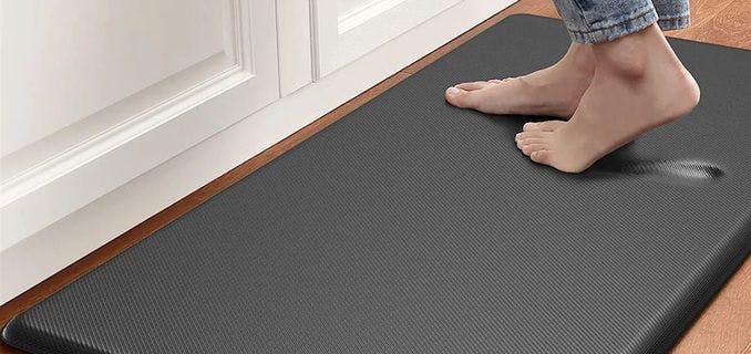 Buy two foam mats and place them near your stove and the sink.