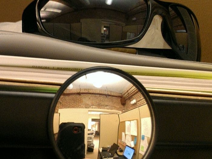 When sitting at a desk with your back to the door, put a pair of sunglasses or tiny mirror to see when people approach.