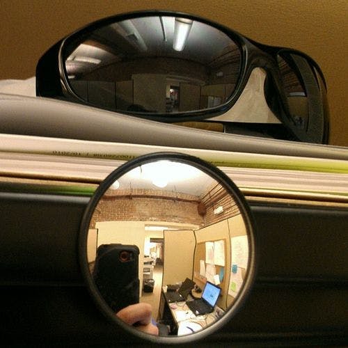 When sitting at a desk with your back to the door, put a pair of sunglasses or tiny mirror to see when people approach.